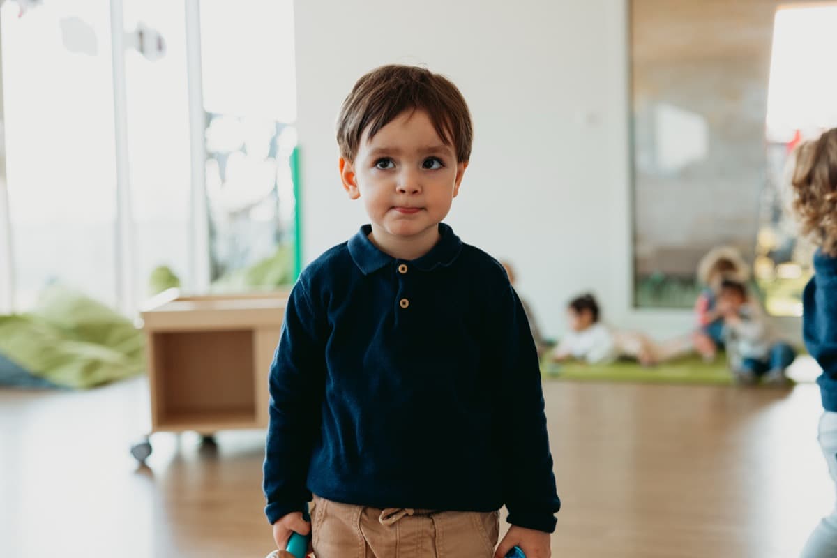 Enfant debout dans la salle de jeux de la crèche Chez Maï