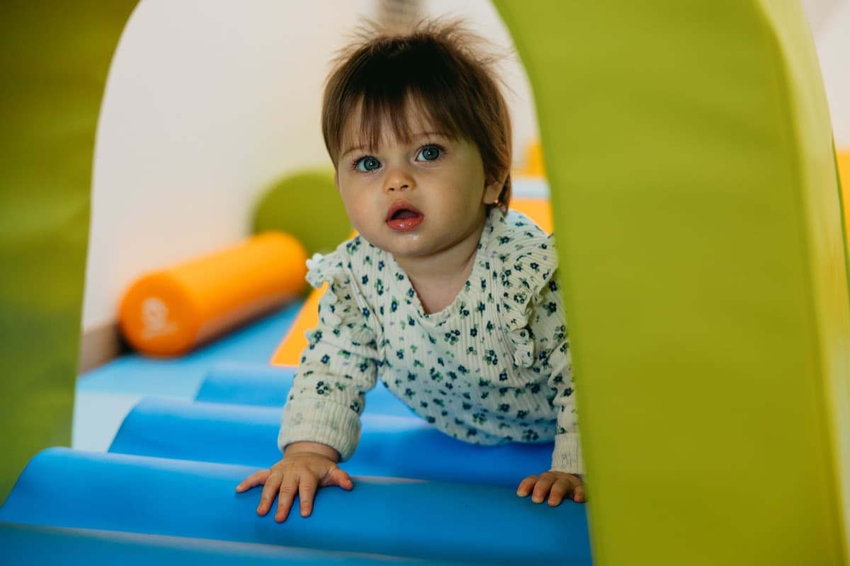 Bébé sur une structure de motricité colorée